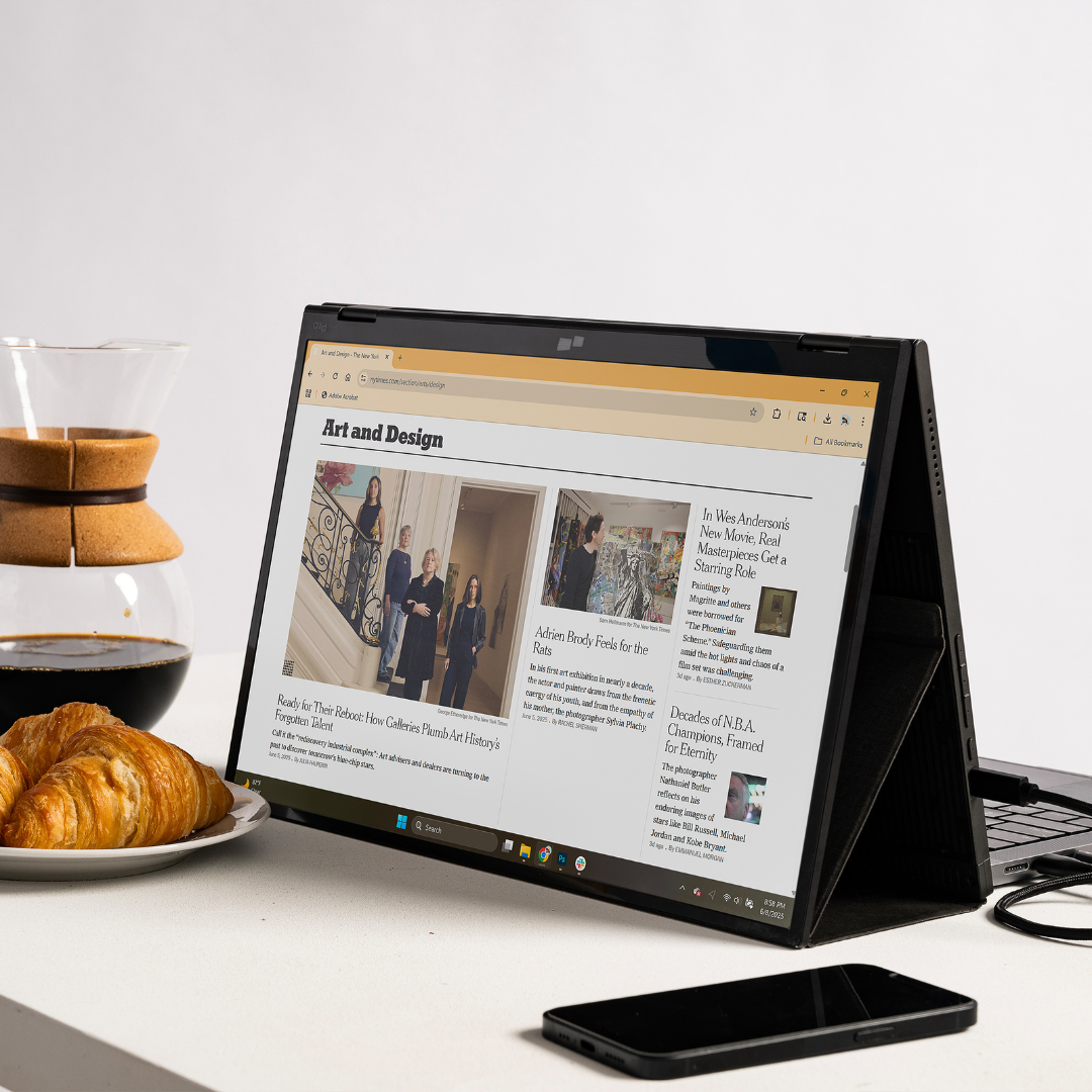 Monitor portátil en modo presentación mostrando contenido web, junto a notebook y celular sobre escritorio