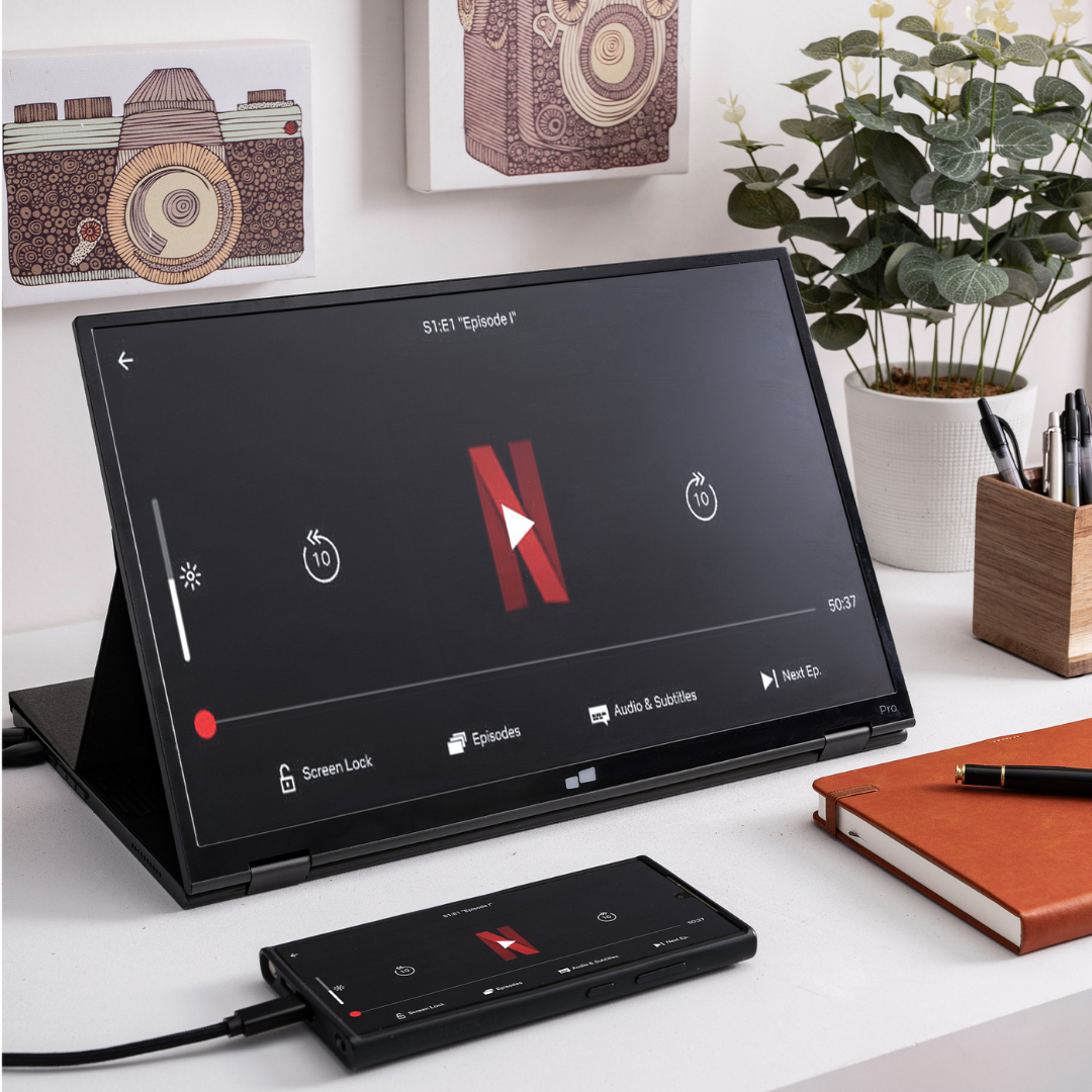 antalla portátil reproduciendo contenido de Netflix conectada a smartphone en escritorio minimalista