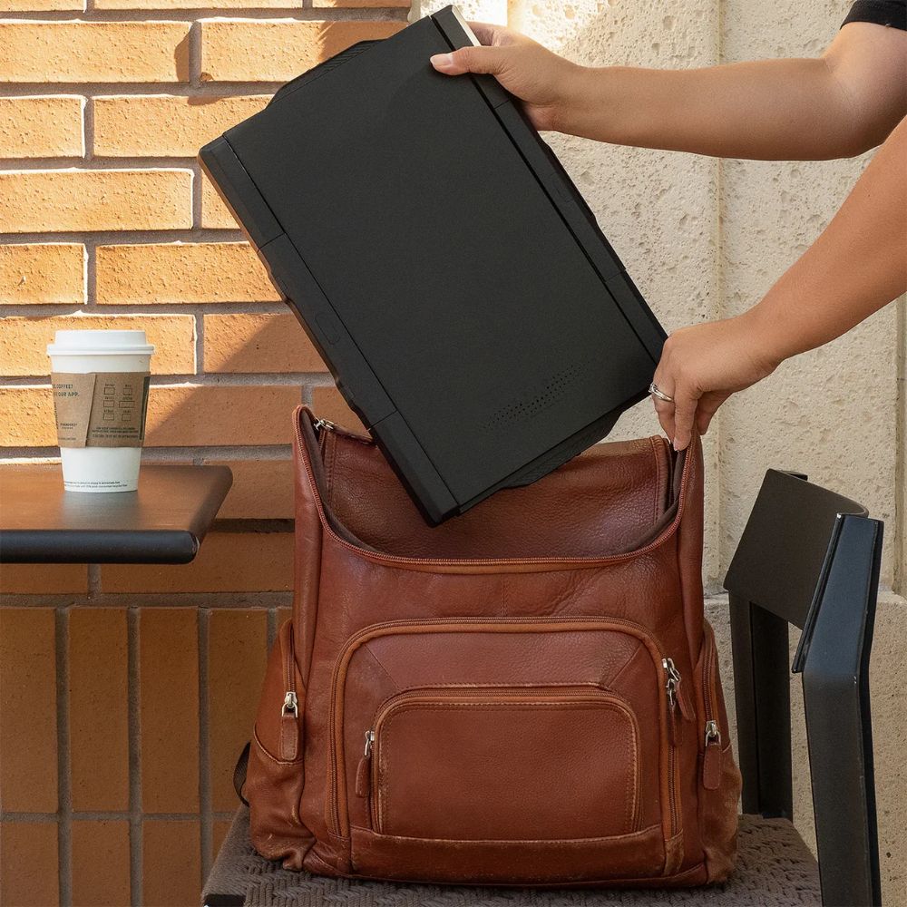Joven mostrando la portabilidad del monitor portátil Mobile Pixels Trio Max al guardarlo fácilmente en su mochila; diseño liviano y compacto ideal para estudiantes, profesionales móviles y trabajo remoto desde cualquier lugar.