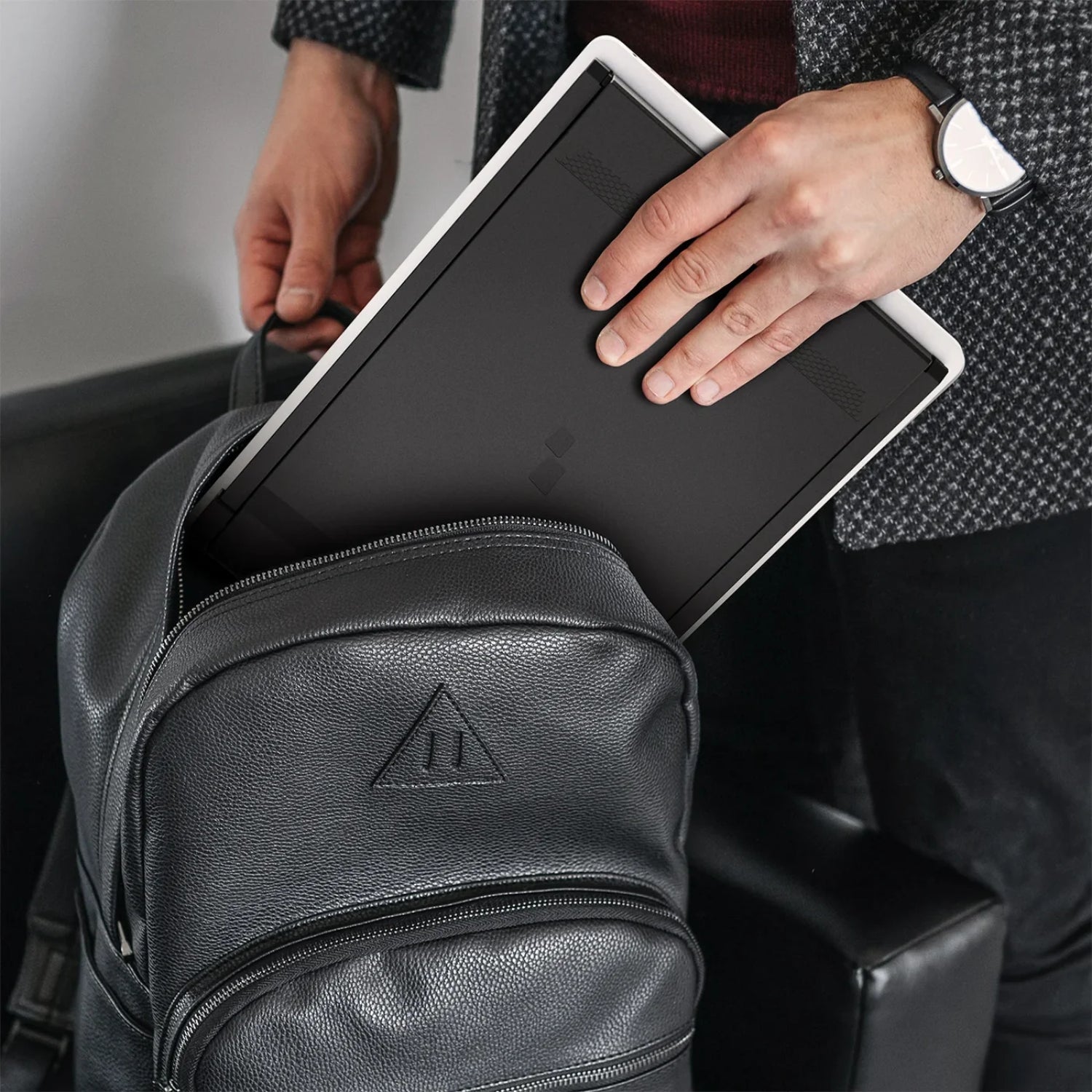 Joven empresario mostrando la portabilidad del monitor portátil Mobile Pixels Duex Max al guardarlo fácilmente en su mochila; diseño liviano y compacto ideal para estudiantes, profesionales móviles y trabajo remoto desde cualquier lugar.