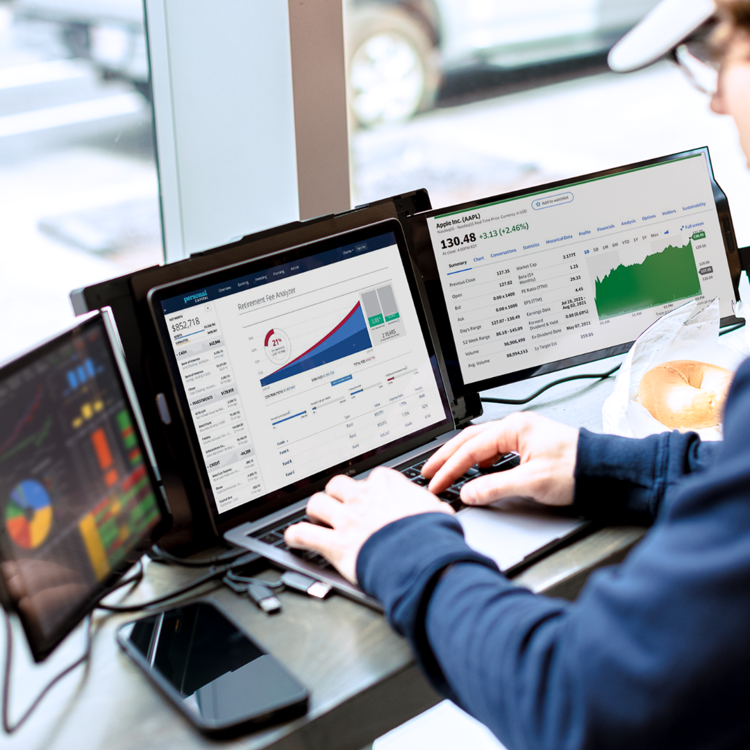 Pantallas Mobile Pixels mostrando gráficos financieros y hojas de cálculo en ambiente de oficina moderna