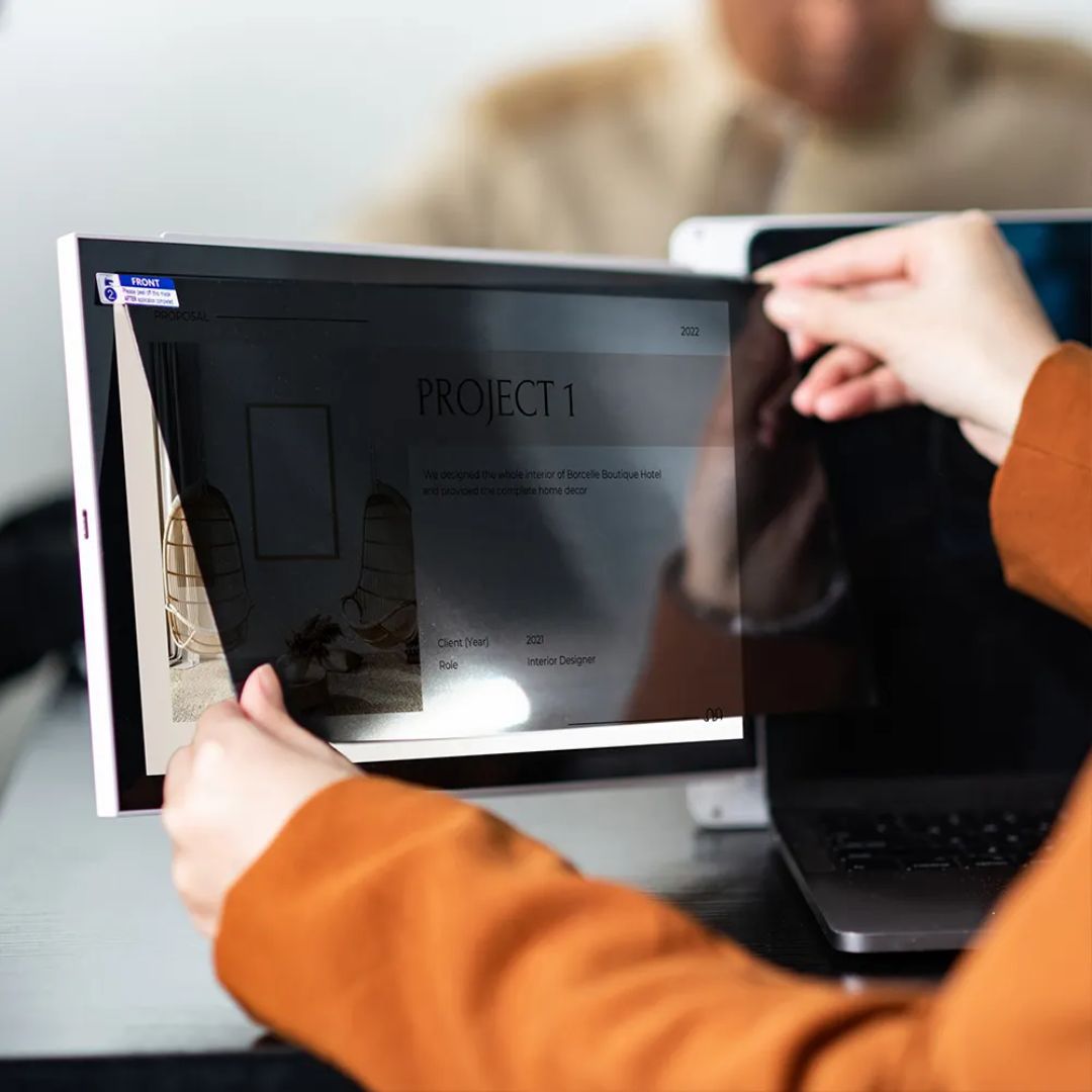 Persona trabajando al aire libre con monitor portátil Mobile Pixels Duex Plus, mostrando la alta calidad de visualización de la pantalla a la luz del día; tecnología ideal para productividad en exteriores, visibilidad nítida y trabajo remoto.