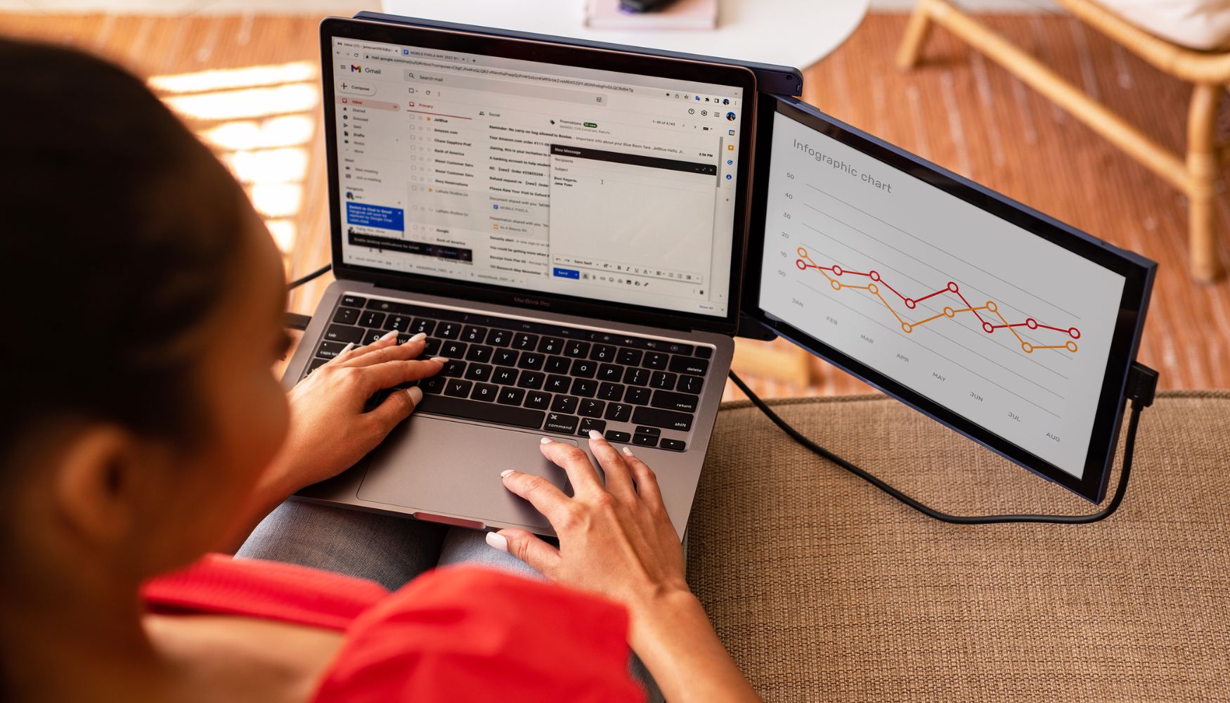 Profesional utilizando monitor portátil Mobile Pixels DUEX Max como segunda pantalla para revisar gráficas mientras envía correos desde su laptop; configuración ideal para productividad, análisis de datos y multitareas.